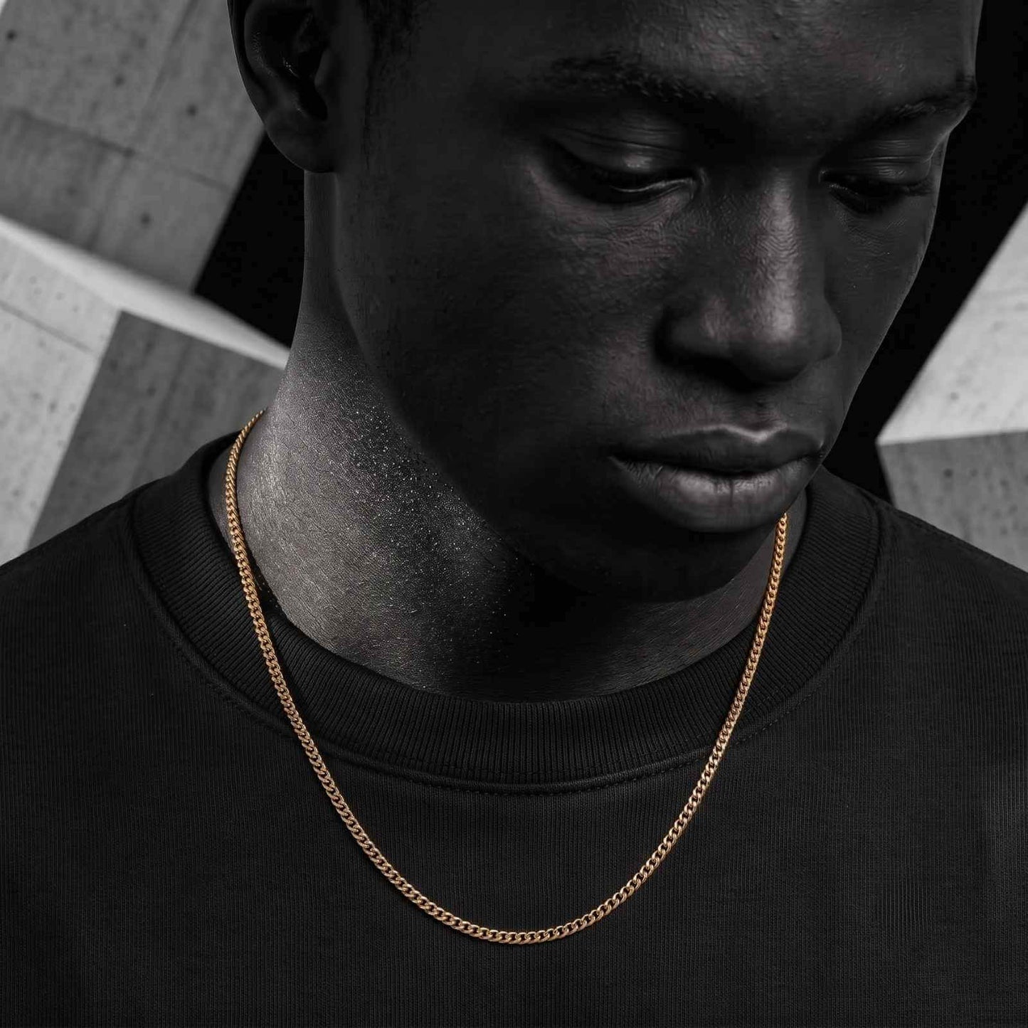 Close-up portrait of a male model wearing the iceX 5mm gold Miami Cuban chain over a black sweatshirt.
