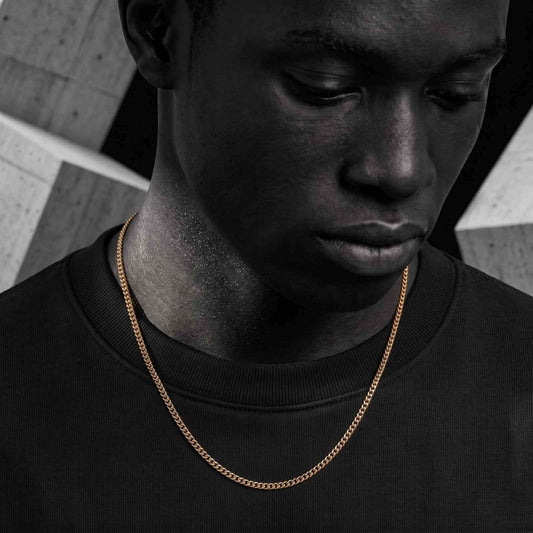 Close-up portrait of a male model wearing the iceX 5mm gold Miami Cuban chain over a black sweatshirt.