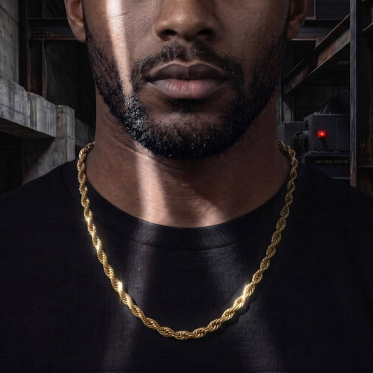 A close-up of a man wearing a 6mm thick, 18K PVD gold rope chain over a black t-shirt, set against a dark industrial background.